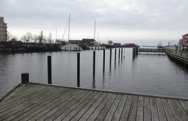 Promenadstråk och kajplatser omger ån. Högra bilden: nedströms Södra Västkustvägen kantas ån av träd på den västra sidan och bebyggelse längs den östra sidan.