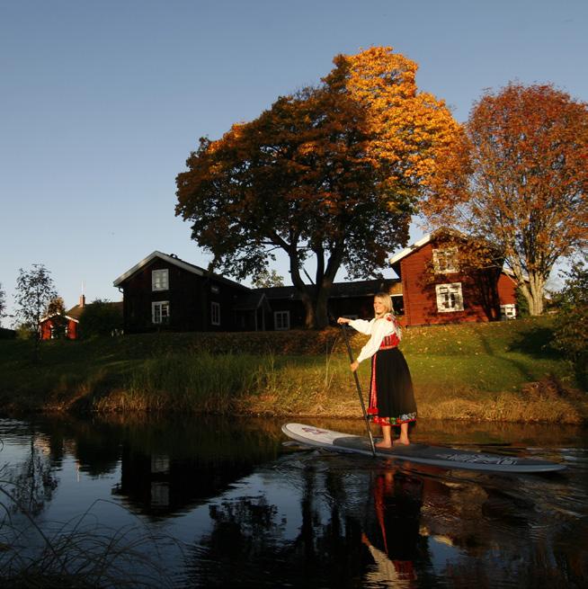 Flokullan Karin Liss paddlar på Noret iklädd Flodas folkdräkt. Med sin karakteristiska påsöm och sitt dekorativa liv väcker den uppmärksamhet.