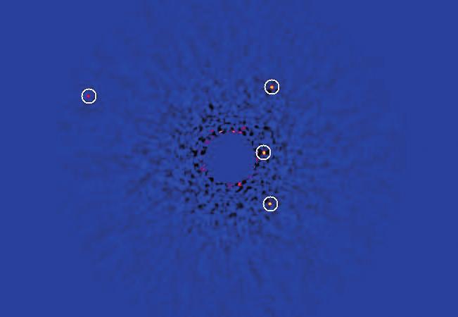 ALEXIS BRANDEKER BILD:NAOJ. Figur 2: Planetsystemet HR 8799 avbildat av Subaru-teleskopet. Stjärnan är dold bakom en mask i mitten, medan planeterna är märkta med ringar.