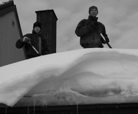 Anders Pettersson och Byron Jackson från Bokdals tog hand om den packade snön på Barbro Rönnows tak på Ladugårdsvägen.