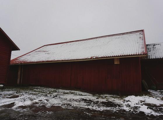 Fasaden har stående slät panel, delvis av kilsågade bräder. Panelen är målad med röd slamfärg. På taket låg fram till omläggningen ett undertak av glesa bräder och däröver pärt.