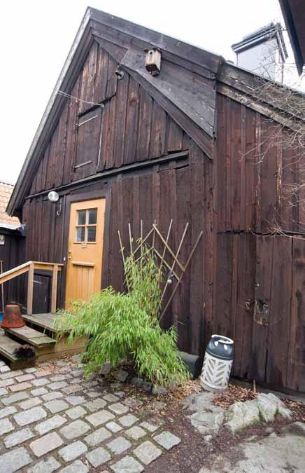Den västra stugan med delar av den äldre panelen bevarad. Till höger syns utbyggnaden som innehöll en äldre tvättstuga med bevarad murad spis. Foto: J. Malmberg. övriga fasader rödmålade.