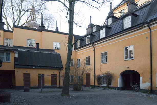 GÅRDEN MED PORTGÅNGEN FRÅN MÄSTER MIKAELS GATA TILL HÖGER. FOTO J. MALMBERG. panel och trädekor är typisk för 1800-talets andra hälft medan husets storlek och takform har 1700-tals karaktär.