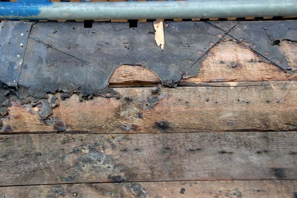 Detalj som visar möllans brädpanel samt delar av papptäckningen. Den smidda spiken (spikhuvudena som är rostiga) var spikade så att ett diagonalmönster bildades på bölet.