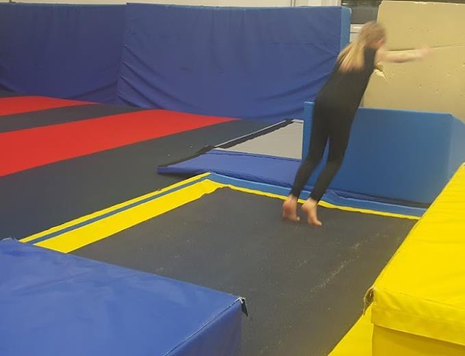 I denna övning så ska gymnasten hoppa från klossen, stämma på tumbling för att sen göra en kullerbytta på kilen.