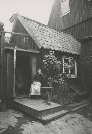 Kvinna utanför Östra varvsgatan 4b. Foto från tiden omkring sekelskiftet 1900, innan tillbyggnaden fanns. Okänd fotograf. SSMF45595.