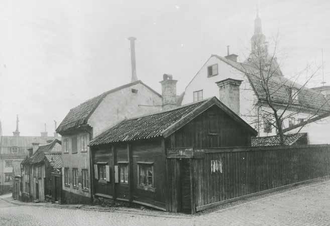 HÖRNET SVARTENSGATAN OCH FISKARGATAN 1904. TRÄHUSET VID SVARTENSGATAN 32A SAKNAR PANEL PÅ LÅNGSIDAN. FOTO ATELJÉ LARSSON, SSM FA13831.