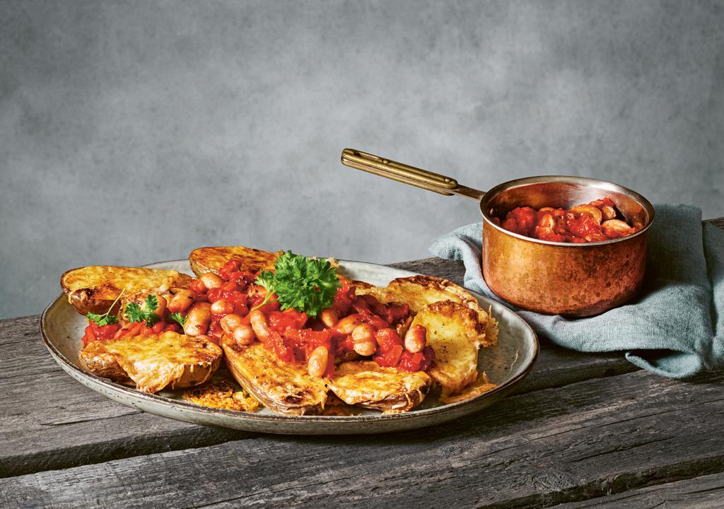 40 Ostgratinerad potatis med varm bönsalsa Ugn: 225 1 kg potatis ½ msk olivolja 150 g lagrad ost, riven 1 tsk paprikapulver ½ tsk cayennepeppar Varm bönsalsa: 1 gul lök, finhackad 1 vitlöksklyfta,