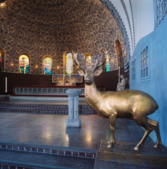 hjorthagens kyrka 7 Korets dekormålade bröstning i mörkbrunt, svart och guld löper runt kor och absid.