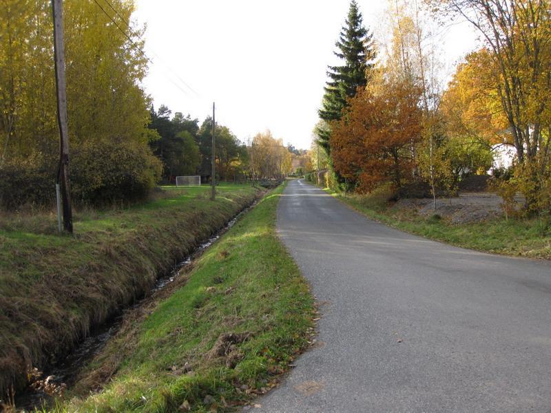 Från denna vändplan fram till sektion ca 0/550 är beläggningen av grus, därefter asfalt resterande del av vägen. Befintlig asfaltbeläggning är i bra skick med enstaka längsgående sprickor.