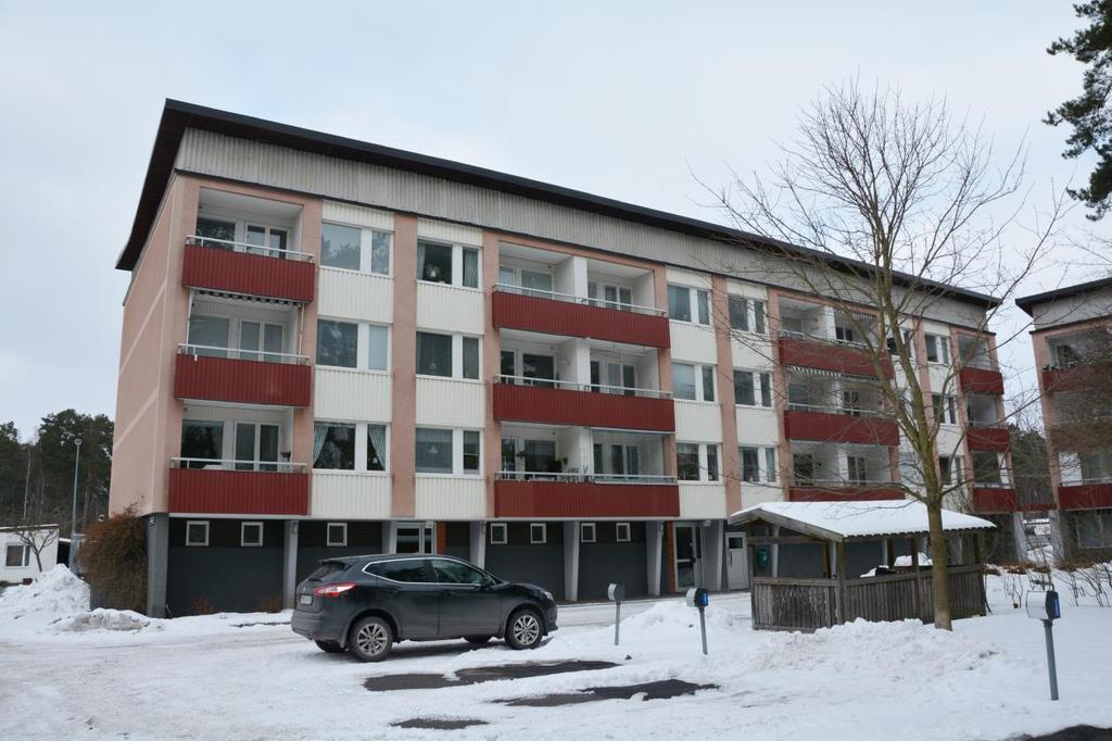 Lamellhus i röd/rosa spritputsad fasad och slätputsade konturer.