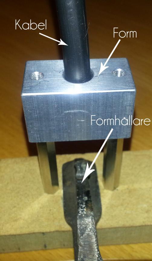 Figur 2.8 Experimentuppställning för formning. 2.4.2 Experiment: Mätning av kraft För att få ett uppskattat värde på den kraft som behövs för att forma kabeländen i formen placerades formen på en våg.