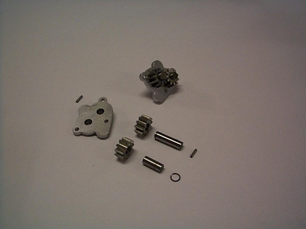 005-04-1. Oljepump. Förmontering av axlar och kugghjul på pumphuslock..1. Var noga med att smörja alla rörliga delar, och pumphuslockets insida, med fett.