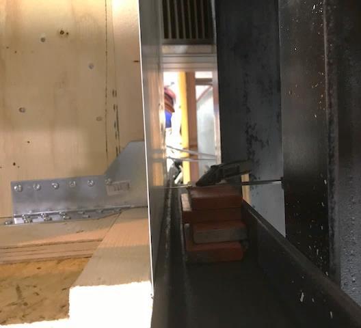 Figur 19. Till vänster i figuren visar skjutmåttets placering på undersidan av balkskon och plåten som spändes fast med tvingar.
