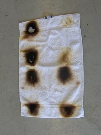 Sida 8(12) Bild 11. Bilden visar handduken helt uppvikt. Vid nästa försök uteslöts vattnet och handduken tog då eld efter ca trettio sekunder.