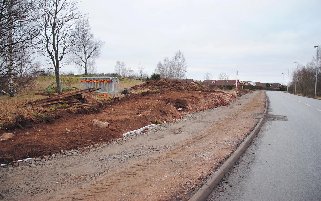 9 Figur 5. Gång- och cykelvägen under konstruktion samt schaktet som löpte över höjdryggen vid Rystad 270 (S234). Foto från nordöst: Ann Westermark. av mörkbrun, sotig silt med kol och skärvsten.