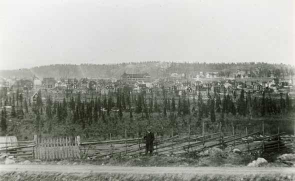 Malmberget i början av 1900-talet. Det så kallade stadsplaneområdet breder ut sig nedanför berget. Centralskolan, en av de byggnader som rivits för att lämna plats åt Gropen, syns mitt i bilden.