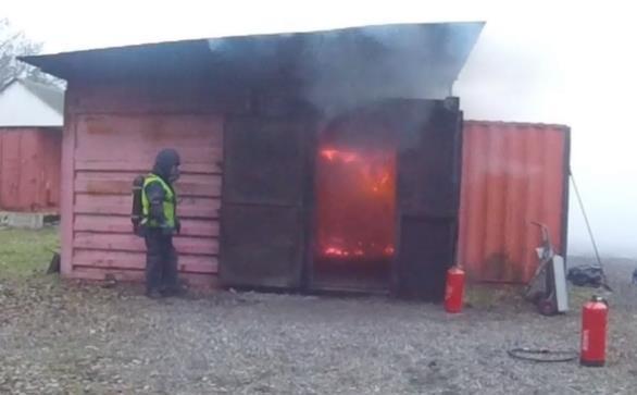 Pulverlansen förs in via hål i dörren i riktning mot branden med pilmarkören och strålbilden riktade uppåt. Temperaturen är 750 C vid tillfället för tömningen av flaskan med 12 kg pulver.