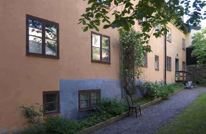 BOSTADSHUSETS FASAD MOT GÅRDEN MED SLÄTA MURAR OCH FÖNSTER I MURLIVET. FOTO J. MALMBERG. manslagningar av lägenheter tillkom utrymmen för badrum.