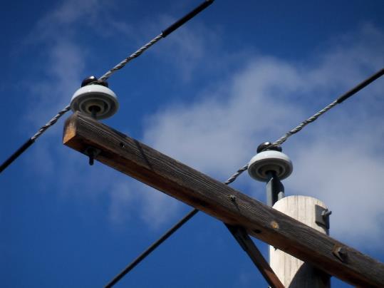 sammanledning till stolpen. En isolator måste vara konstruerad på ett sådant sätt att den kan motstå både de mekaniska och de elektriska påfrestningarna.
