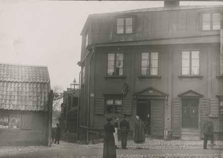 Bild från tiden omkring sekelskiftet 1900 med folksamling utanför butiken. Foto: A. Malmström.