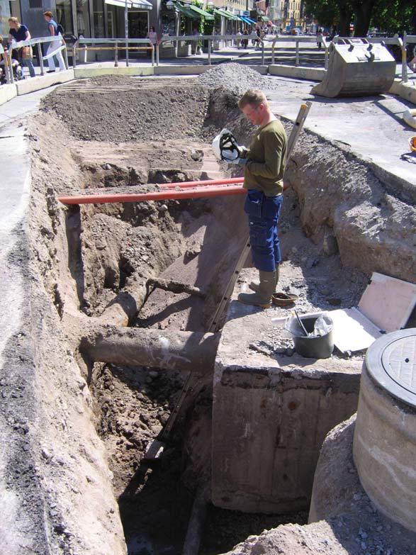 Schakt 19 Schaktdjup 2-3 meter. Samtliga schaktkanter helt störda. Fyllnadsmassor av modern sandfyllning och omrörda, sandiga, kulturlagerblandade massor med bl a stora bitar av tegelstenar.