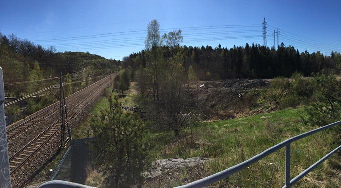Sida 9 (31) Foto: Vy mot sydöst. I fonden syns kraftledningarna på bergknallen strax söder om planområdet. Bilden tagen från gångvägen intill brofästet.