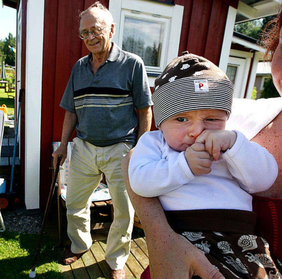 Kaffepaus. I mamma Kinas knä står Herman stadigt.