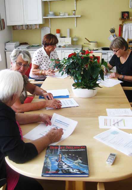 Smakpanelsmedlemmar i Halmstad betygsätter måltiden på Frennarps äldreboende. Vi delar bord med några av de boende. Det finns färska blommor på bordet.