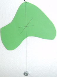 Ta reda på tyngdpunkten för en oregelbunden figur Rita och klipp ut en figur i kartong. Använd en tråd som är lite längre än kartongfiguren.