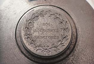 Vattenskadad medaljstamp. Läckande rör i museimagasin är inte ovanligt. Medaljstampen efter rengöring.