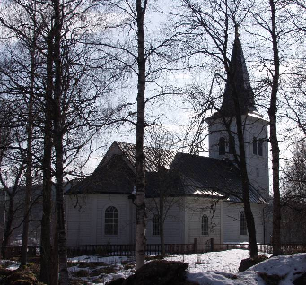 Kyrkoanläggningen Kyrkogården som breder ut sig söder om kyrkan har rektangulär utformning och är terrasserad. En stödmur i granit omgärdar och på denna ett oljat spjälstaket med överliggare.