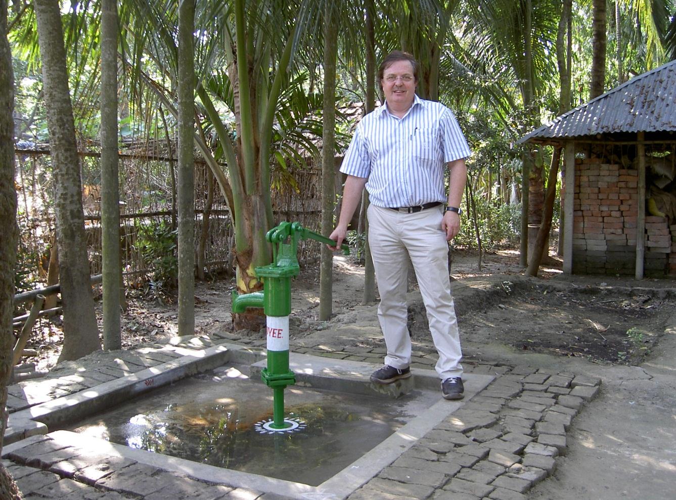 Berndt Sanfridsson står vid en brunn i Bangladesh som han varit med och borrat.