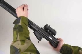 Underbeslag Magasinsspärr Bild 34 Demontering låsbult 3. Tryck ut underbeslagets låsbult. Avtryckare Bild 35 Demontering underbeslag 4. Dra underbeslaget nedåt-bakåt.