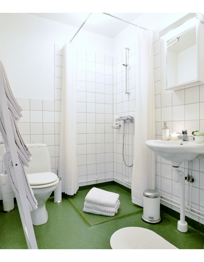 Badrum Stort badrum med delvis vita kaklade väggar kombinerat med mörkare