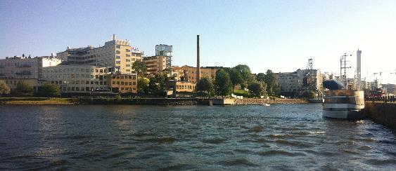Figur 23 Lumaområdet sedd från norr. Industribebyggelsen utgör ett tydligt landmärke i stadslandskapet och den visuella upplevelsen förstärks ytterligare av läget intill Hammarby sjö.