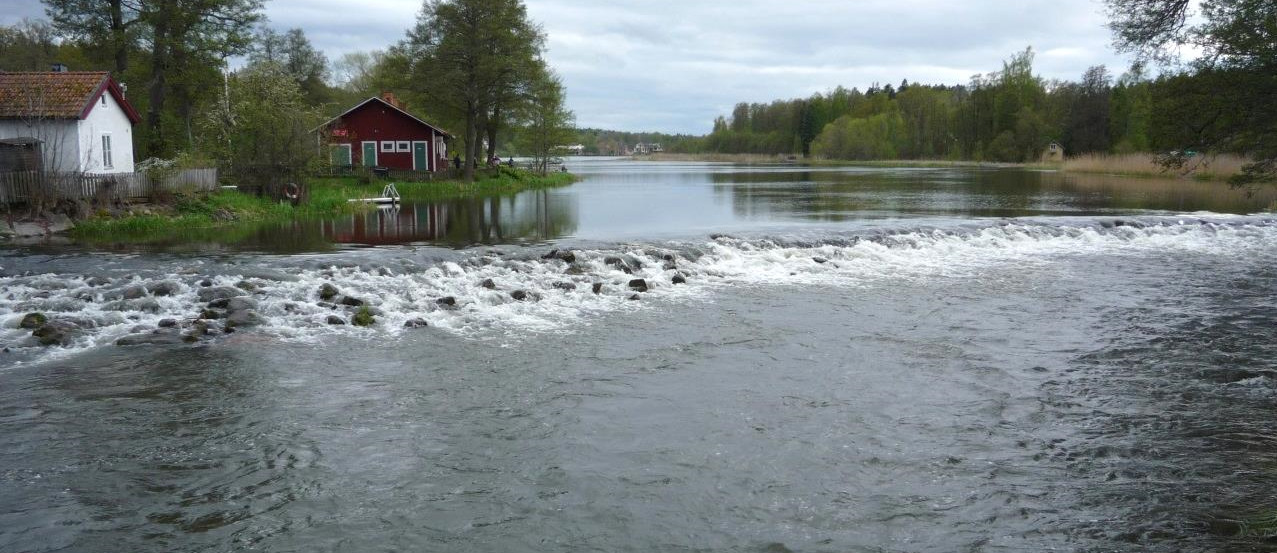 dammarna vid fd Tunafors fabriksbyggnad, som för närvarande omvandlas till bostäder, och vidare via den öppna terrängen norr om fabriken till ån.