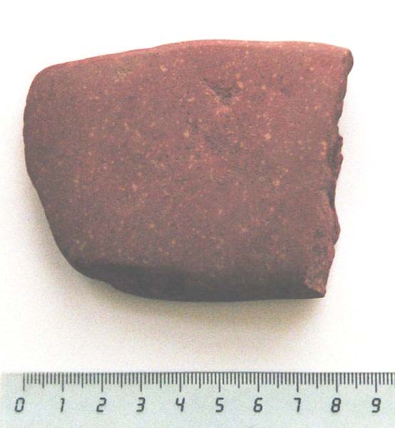 Foto 4. Yxan i röd porfyr påträffades i den södra delen av schakt 4 (se fyndlista, figur 4, samt karta, bilaga 2).