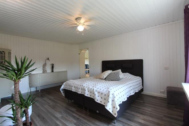 Sovrum 1 master-bedroom med stor walk-in-closet. Laminatgolv och vit panel på väggar och tak.