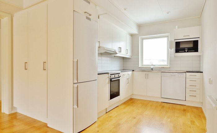 Köksdel Köket är i öppen planlösning med vardagsrummet. Vita skåpluckor med vitt kakel över bänk.
