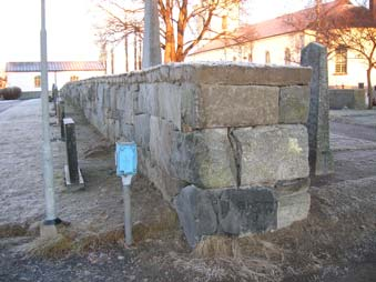 10 Muren är grundlagd som skalmur bakom graven 2004 11 26. Urspunglig murdel mot väster (t h). Mur vid graven, där tujorna stått under återuppbyggnad.