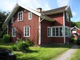 Mangårdsbyggnader av västsvensk dubbelhustyp med välbevarad träpanelarkitektur och vinkelställda ladugårdar.