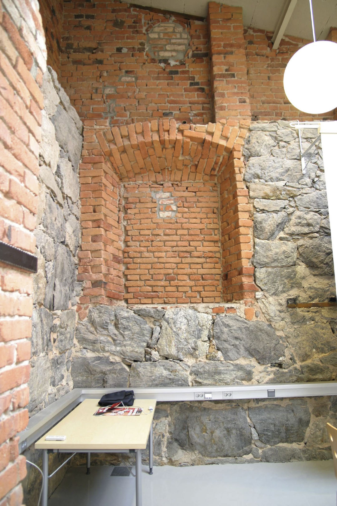 ) Rummens ytterväggar är murade och utgörs av natursten och rött tegel med inslag av gult tegel. I det västra rummet fi nns tre murstockar, två mot söderväggen och en mot norrväggen.