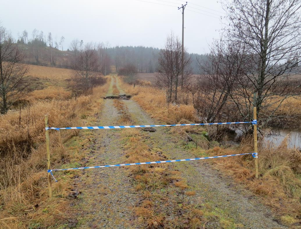 Bild 3. Vägen har spärrats av. Trumman på bild 1är belägen strax innanför avspärrningen. Erosionsskadorna syns ca 20 meter in på vägen.