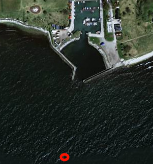 FIGUR 3. Ungefärlig provtagningspunkt för sediment (röd oval) ca 280 m ut från inloppet till Smygehamn (Eniro-bild).