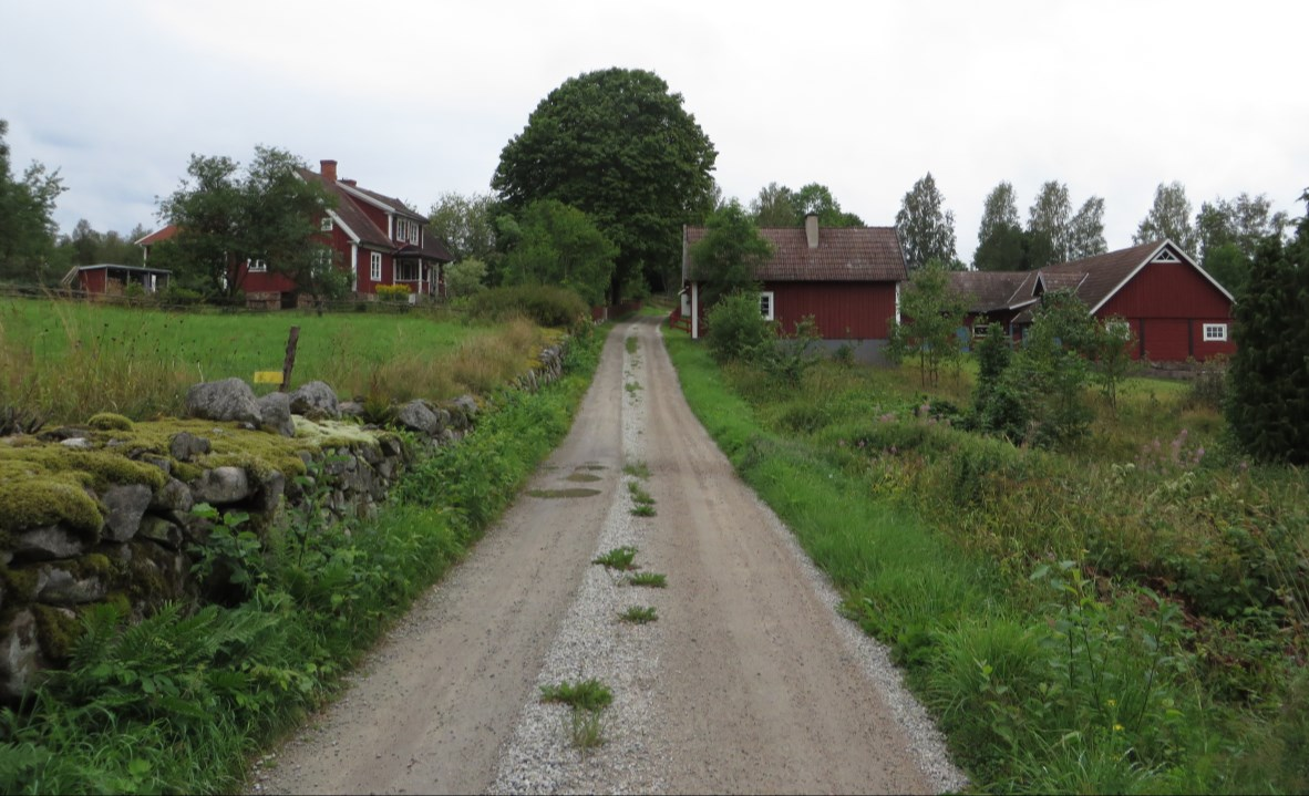 På höjden ses mangårdsbyggnaden och ekonomibyggnaderna till Mundekulla 1:2.