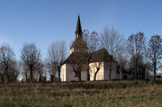 skå kyrka 5 Exteriör från sydost. plåt. Ett flertal är från sekelskiftet 1700 och har smideskarmar med rosor i skärningspunkterna. Såväl fönster- som dörrsnickerier är målade i grått.