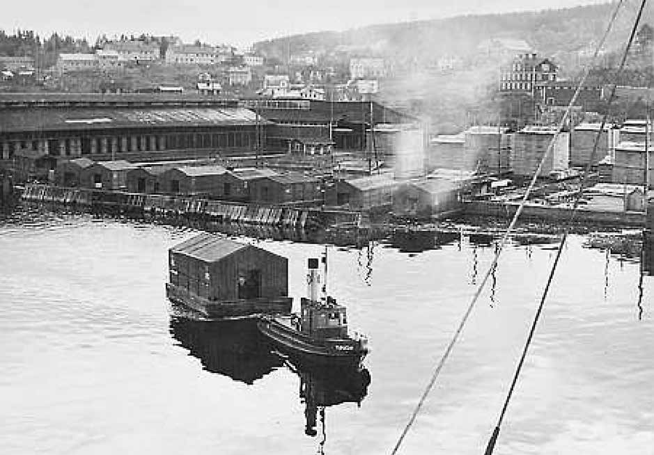 Fig. 5. Bilden visar brädgården och hyvelskjul med hamnbåten Tunadal i förgrunden.