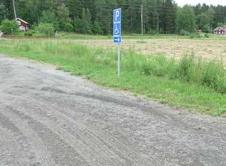 Parkeringsyta placerad i ytterkant av parkeringsplatsen, tillgänglig för ur- och istigning på sidan.