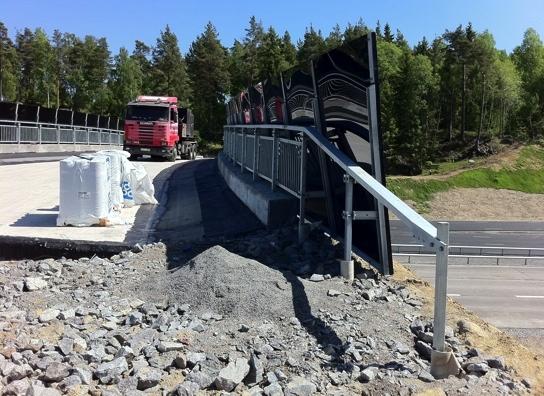 Exempel på avskärmning i trä med växtlighet på, från en ekodukt i Frankrike. Stenarna framför skärmen bildar en torr miljö som uppskattas av kräldjur, insekter och många ängsväxter.
